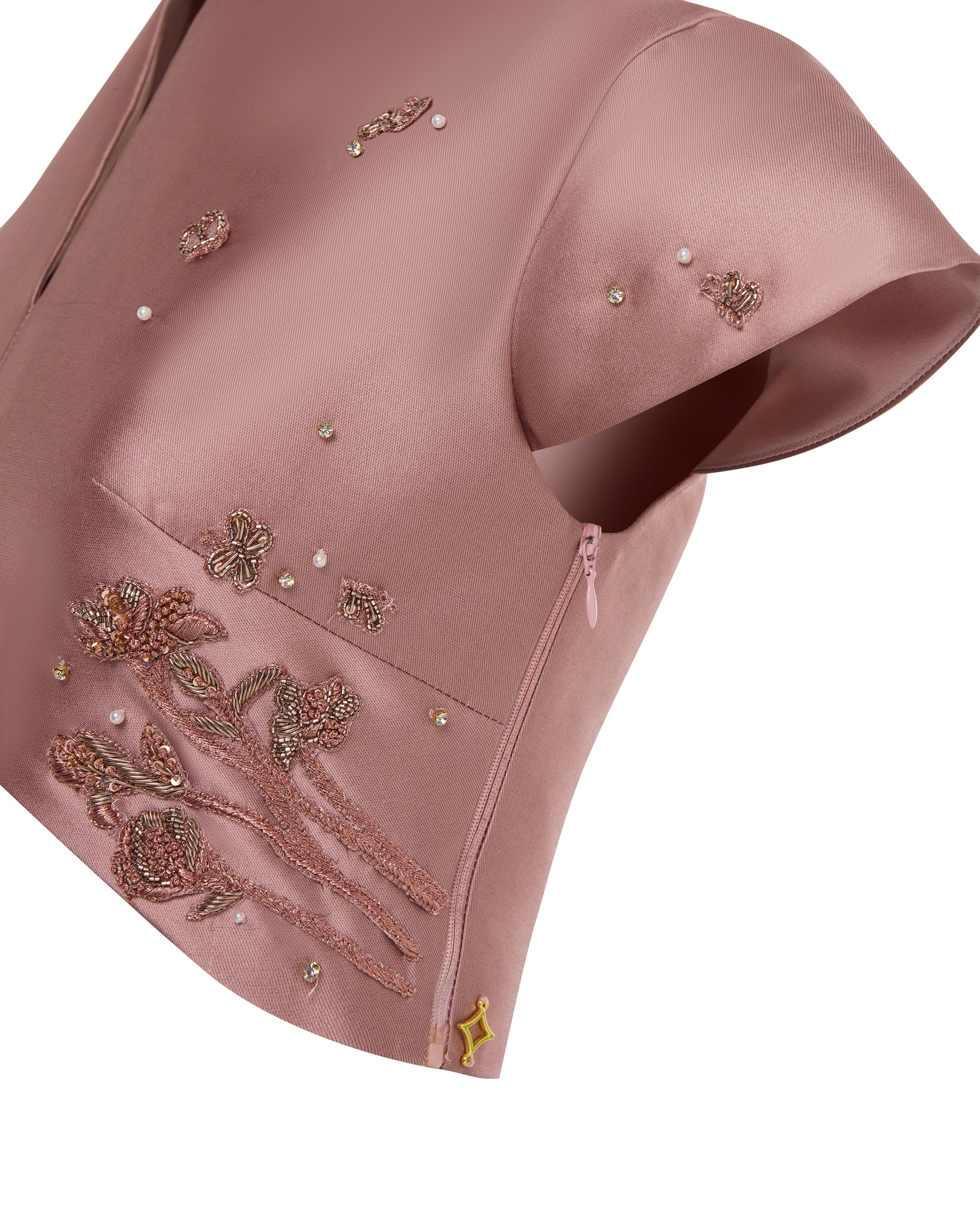 Pink cropped top with embroidery, close up.
