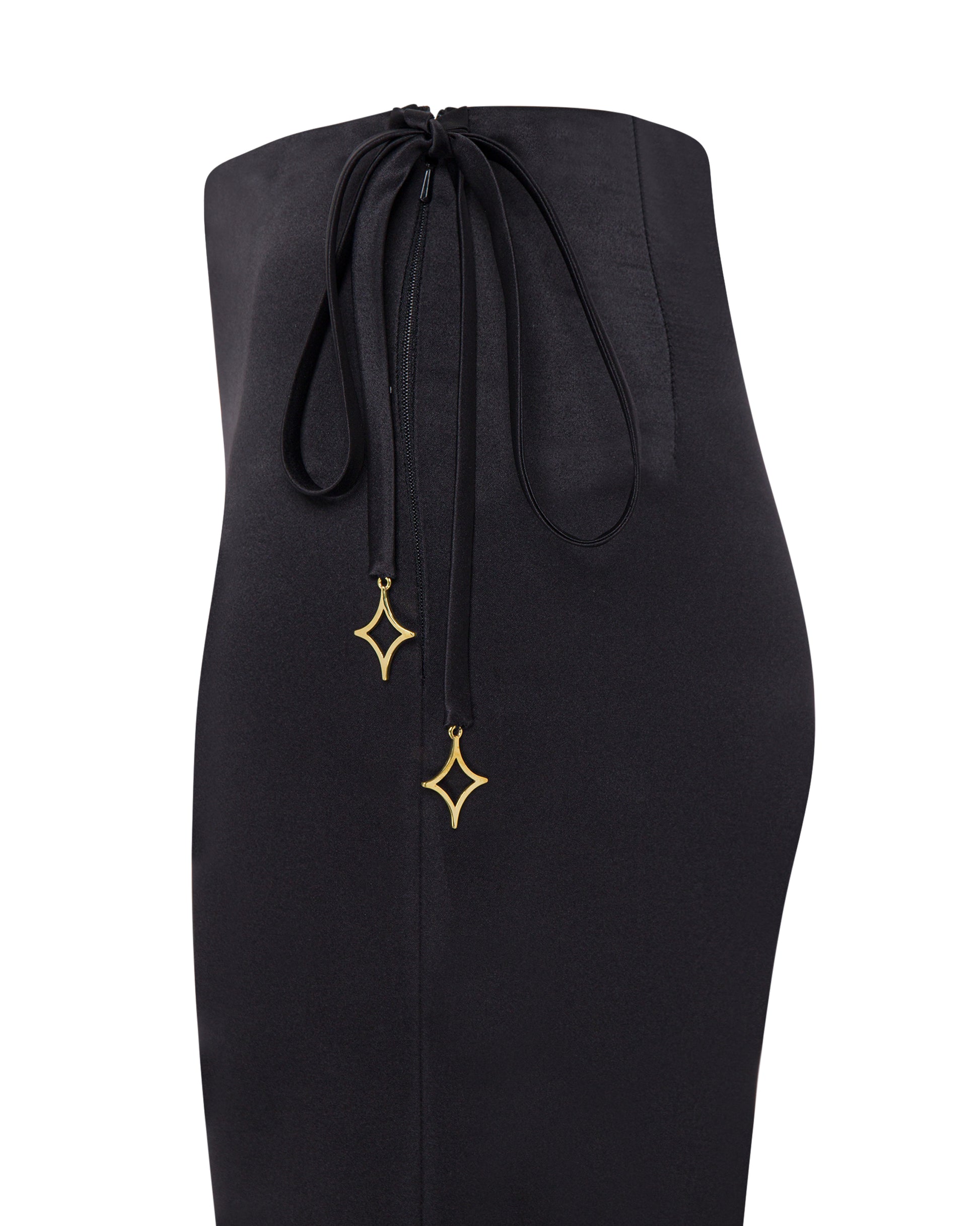 Satin black high waisted pants with scattered feathers. Close up