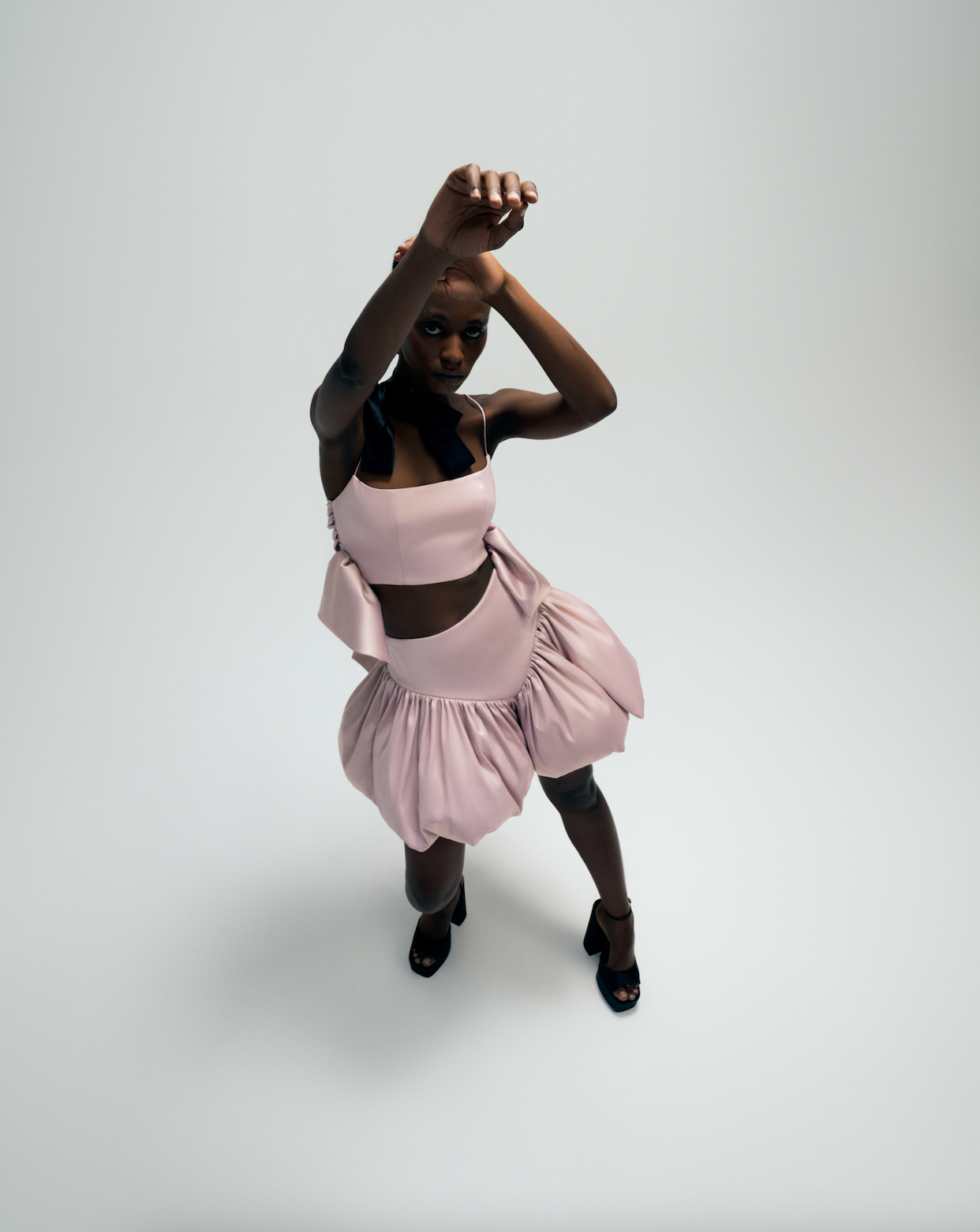 Pink bralette with side bow detailing, Pink high waisted balloon skirt, front. 